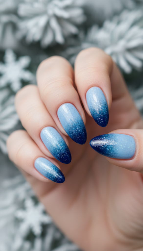A close-up view of elegant gradient icy nails, showcasing a stunning transition from pale blue at the cuticles to deep navy at the tips, reflecting a shimmering, frosty finish. The nails are neatly manicured, extending gracefully against a softly blurred winter background of frosted pine branches. Soft, diffused lighting casts a gentle glow, emphasizing the cold, crystalline texture of the nail polish while creating a serene and sophisticated atmosphere. The shot is captured with a macro lens to focus on the intricate details of the nail art, emphasizing the smooth gradients and ice-like sparkle. The overall mood is wintry and elegant, perfectly capturing the essence of icy nail designs. A close-up view of elegant gradient icy nails, showcasing a stunning transition from pale blue at the cuticles to deep navy at the tips, reflecting a shimmering, frosty finish. The nails are neatly manicured, extending gracefully against a softly blurred winter background of frosted pine branches. Soft, diffused lighting casts a gentle glow, emphasizing the cold, crystalline texture of the nail polish while creating a serene and sophisticated atmosphere. The shot is captured with a macro lens to focus on the intricate details of the nail art, emphasizing the smooth gradients and ice-like sparkle. The overall mood is wintry and elegant, perfectly capturing the essence of icy nail designs.